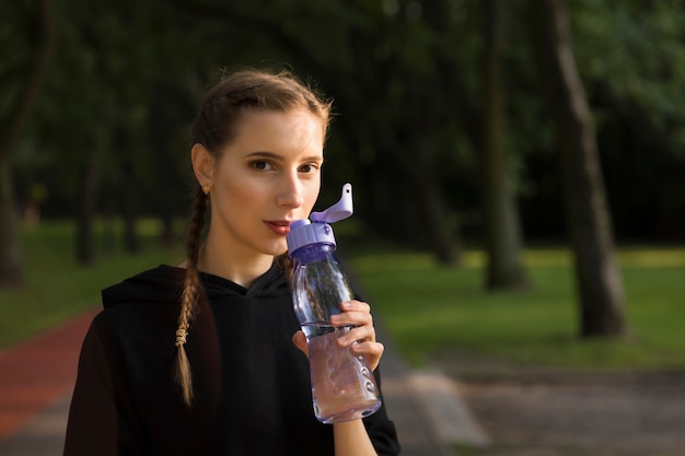 Mooie jonge blanke vrouw in fitness slijtage uit te werken in een park.