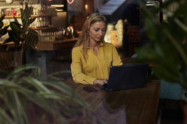 Mooie jonge blanke zakenvrouw die op laptop werkt