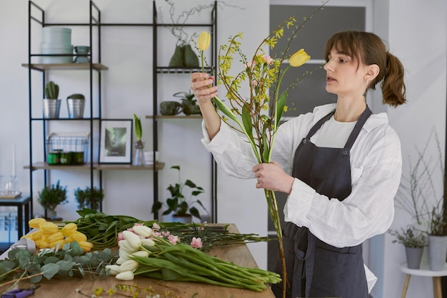 Mooie jonge bloemist maakt een boeket