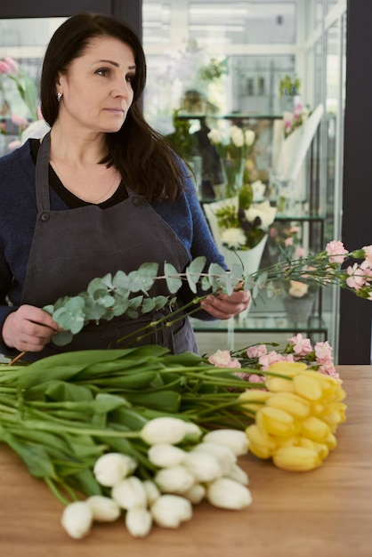 Mooie jonge bloemist maakt een boeket