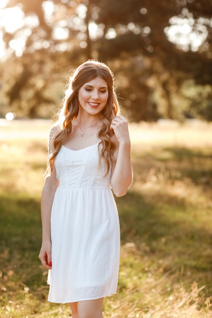 Mooie jonge blonde vrouw in het park op een warme zomerdag