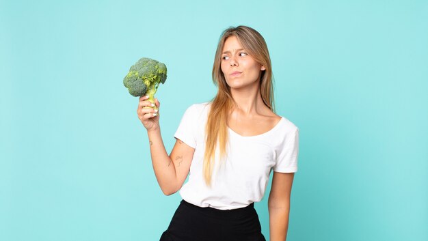 Mooie jonge blonde vrouw met een broccoli