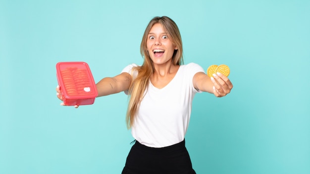 mooie jonge blonde vrouw met een tupperware