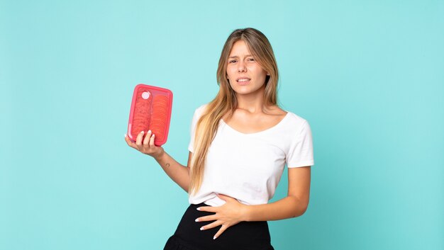 Mooie jonge blonde vrouw met een tupperware