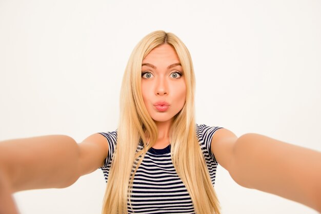 Foto mooie jonge blonde vrouw selfie maken en steenbolk