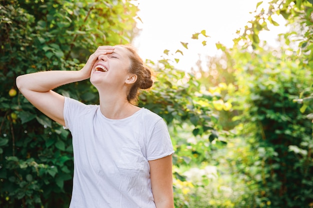 Mooie jonge brunete vrouw die op park of tuin groene achtergrond rust