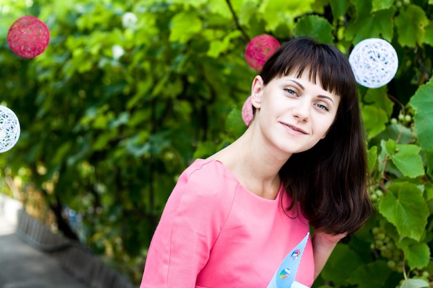 Foto mooie jonge brunette in een roze jurk