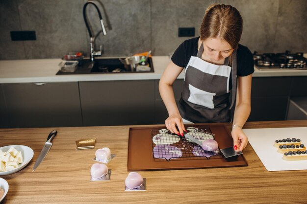 Mooie jonge chef-kok die heerlijk dessert verfraait