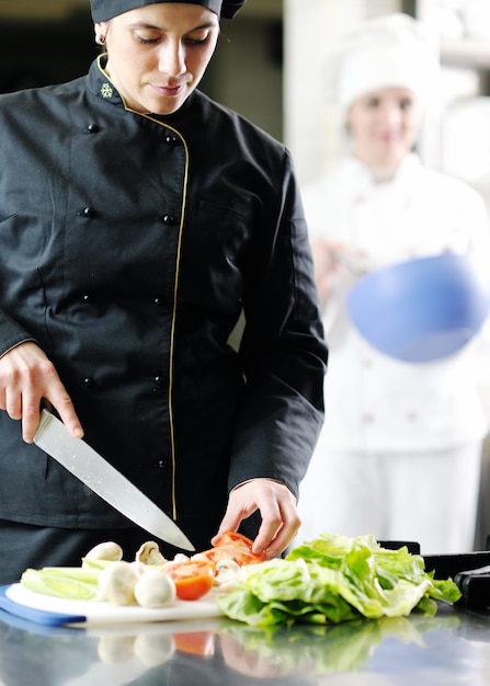 mooie jonge chef-kokvrouw bereidt en decoreert lekker eten in de keuken