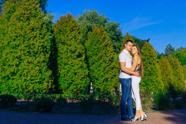 Mooie jonge gelukkige verliefde paar knuffelen tijd doorbrengen in een zomerpark in de natuur