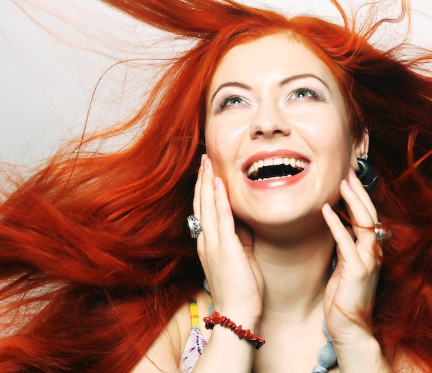 Foto mooie jonge, gelukkige vrouw met lang, bloeiend rood haar.