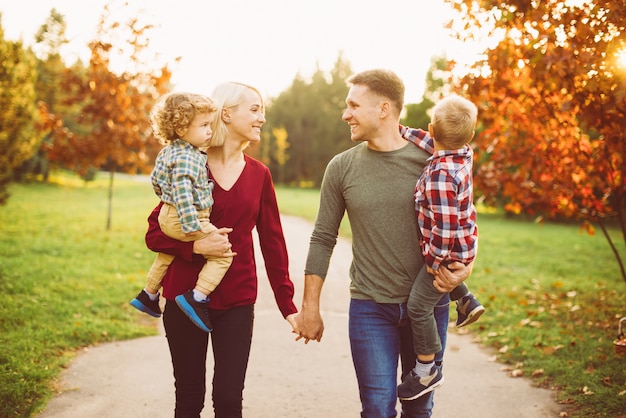 Foto mooie jonge gezin wandelen in het park en plezier maken met kinderen