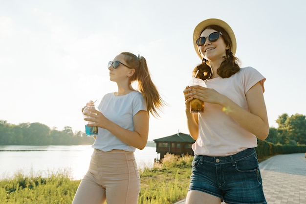 Mooie jonge glimlachende tienermeisjes die op aard lopen