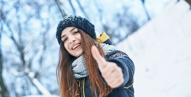 Mooie jonge glimlachende vrouw bij goed gelukkig de winterweer