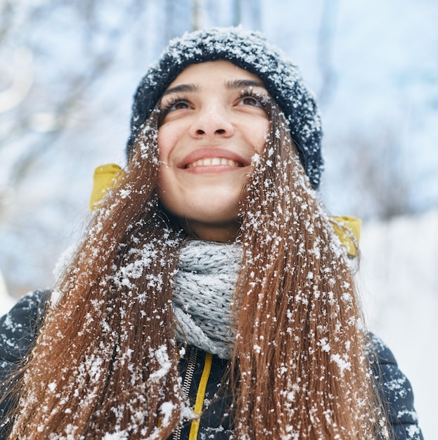 Mooie jonge glimlachende vrouw buiten in de winter