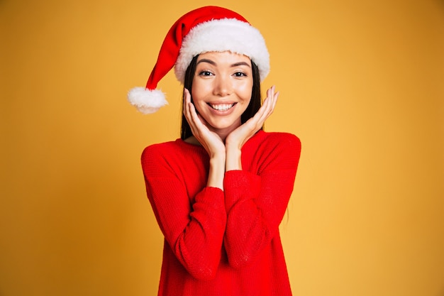 Mooie jonge glimlachende vrouw in geïsoleerde Kerstmanhoed