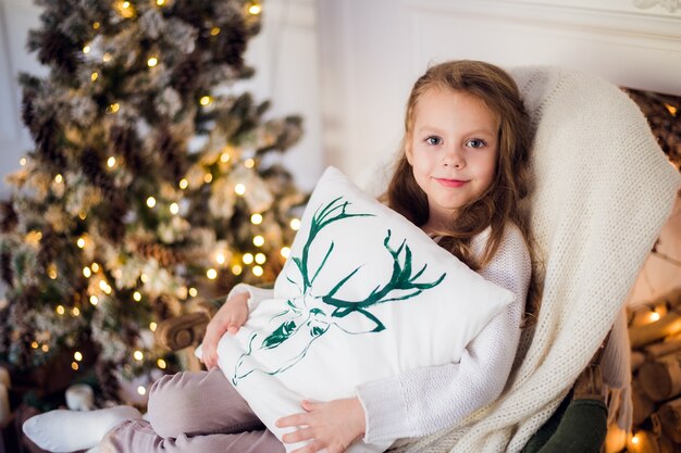 Mooie jonge jongen gewikkeld in een deken tegen de kerstboom