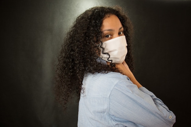 Mooie jonge Latina met een medisch masker