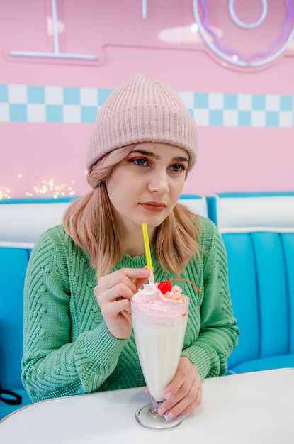 Mooie jonge meisje het drinken vanillemilkshake in koffie