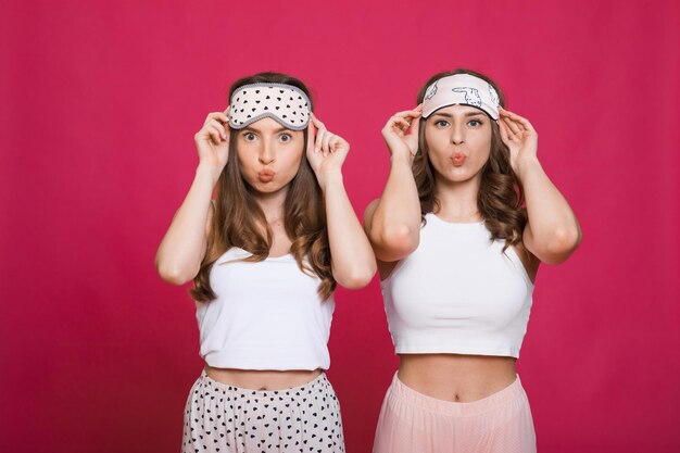 Foto mooie jonge meisjes 20s dragen kleurrijke gestreepte pyjama's met plezier