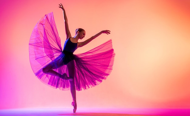 Mooie jonge meisjesballerina in pointe-schoenen en een zwempaksilhouet op een heldere rode achtergrond.