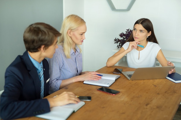 mooie jonge mensen op kantoor aan tafel met een laptop