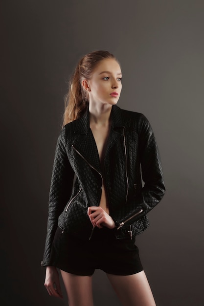Mooie jonge model poseren voor modeltests in zwart leren jas