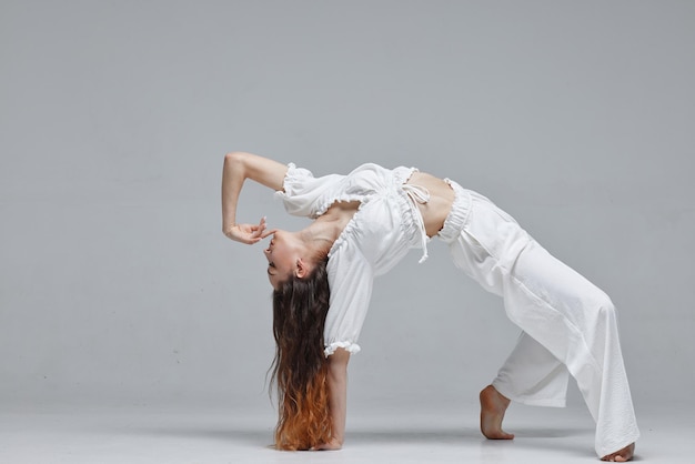 Mooie jonge moderne danser of fitnessdanser op een witte geïsoleerde achtergrond