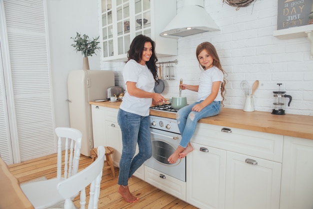 Mooie jonge moeder en dochtertje samen koken