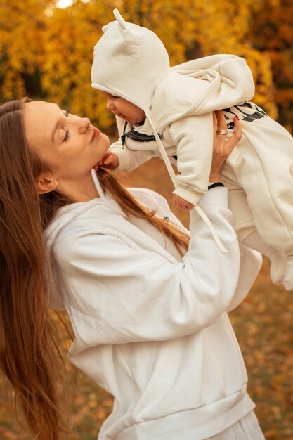 Mooie jonge moeder met babymeisje in de herfst