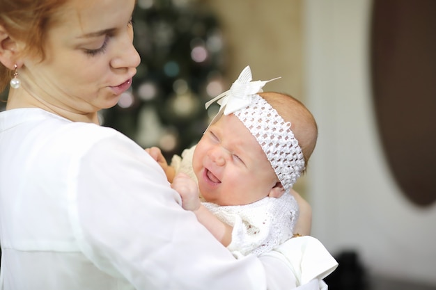 Mooie jonge moeder met een pasgeboren dochter in haar armen