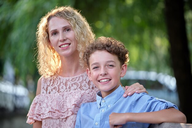 Mooie jonge moeder met haar zoon die samen van tijd geniet in het zomerpark. Gelukkig familie vrijetijdsactiviteit concept