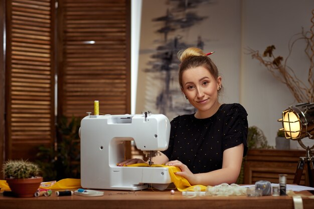 Mooie jonge naaister bezig met naaimachine