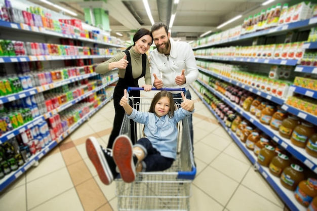 Mooie jonge ouders en hun schattige dochtertje glimlachen tijdens het kiezen