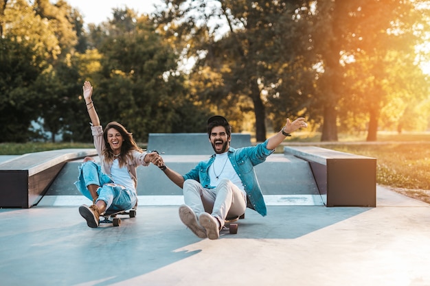 Mooie jonge paar genieten van buiten in de stad skateboarden park.