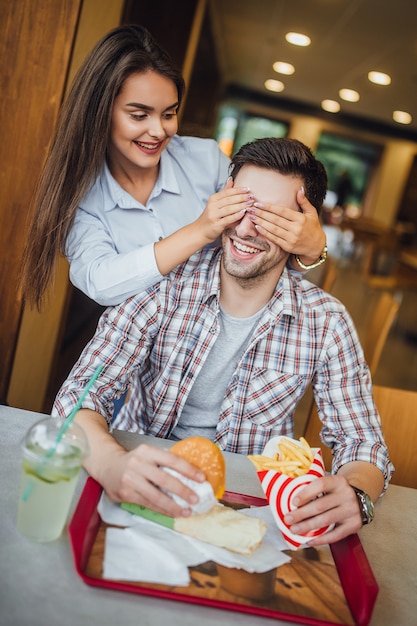 Mooie jonge paar in het moderne fastfoodrestaurant plezier