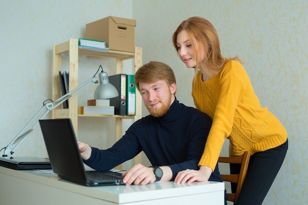 mooie jonge paar man en vrouw die op laptop werkt