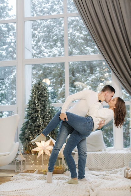 Mooie jonge paar poseren voor fotograaf bij nieuwjaarsstudio kerstboom sneeuw buiten