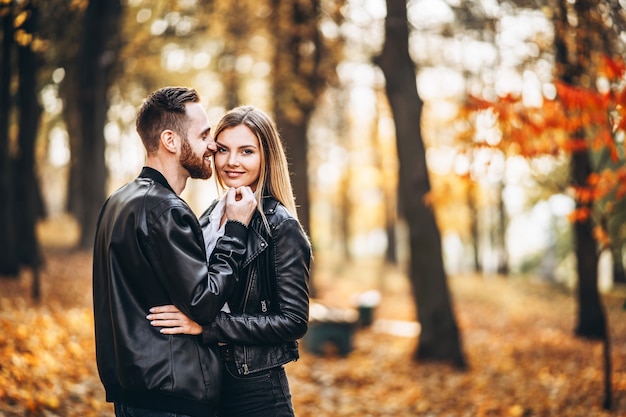 Mooie jonge paar wandelen in de herfst park op een zonnige dag