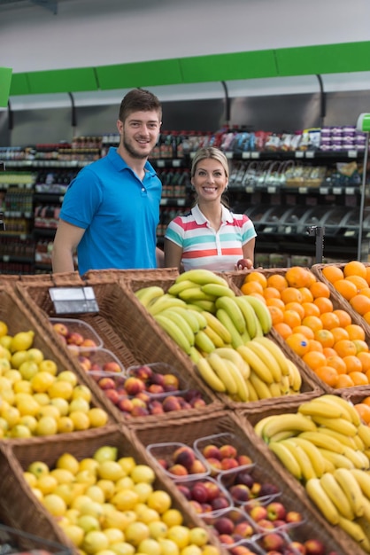 Mooie jonge paar winkelen voor groenten en fruit in de productieafdeling van een supermarkt Supermarkt ondiep diep van het veld