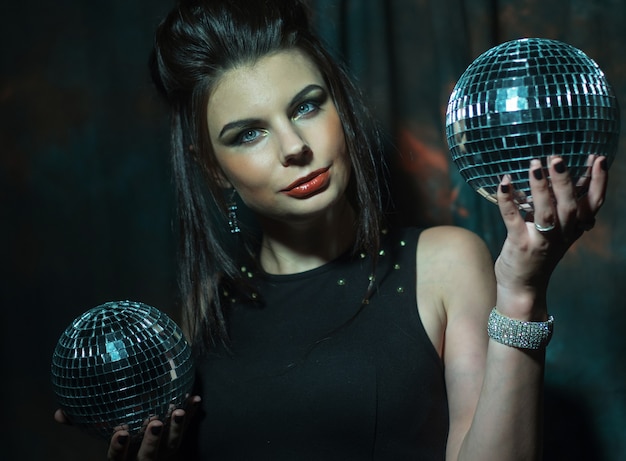 Mooie jonge sensuele vrouw met discoballen