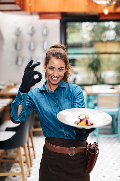 Mooie jonge serveerster die in exclusief restaurant werkt.