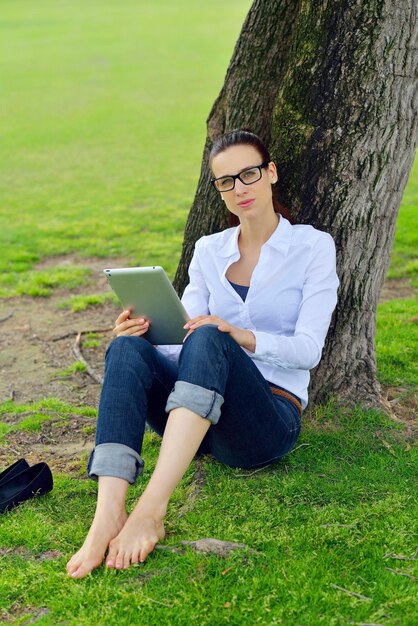 Mooie jonge student vrouw studeren met tablet in park