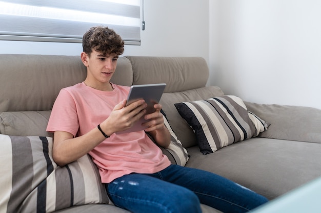 Mooie jonge tiener die in de woonkamer thuis een videogesprek voert met de tablet