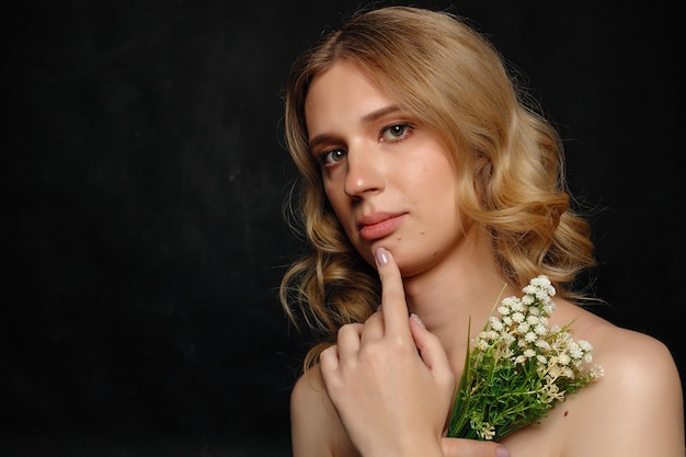 Mooie jonge transgender met blond haar met bloemen