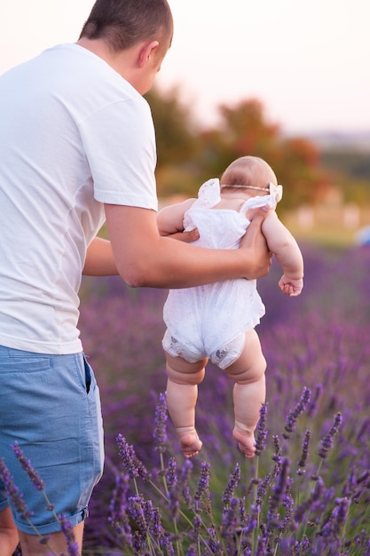 Mooie jonge vader met baby op lavendelveld