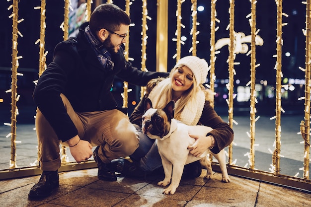 Mooie jonge verliefde paar genieten van Kerstmis of Nieuwjaar nacht op een straat in de stad.