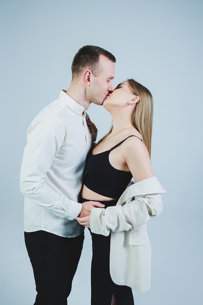 Mooie jonge verliefde paar knuffelen op een witte achtergrond Een stijlvolle paar omarmt en geniet van gevoelens Mannen en vrouwen in stijlvolle casual kleding