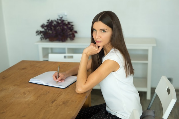 mooie jonge vrouw aan de tafel in het kantoor