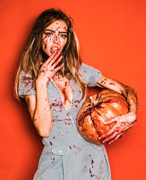 Mooie jonge vrouw als sexy vampier halloween-concept Eng bloedig zombiemeisje met pompoen Woman